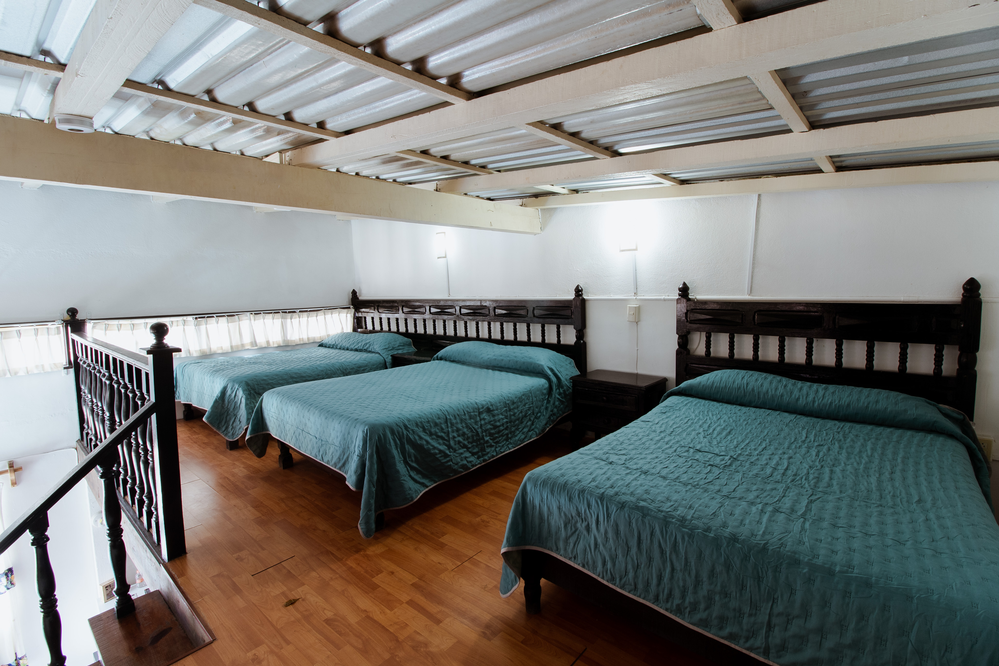 Habitación Grupal, segundo piso con 3 camas matrimoniales y barandal colonial
